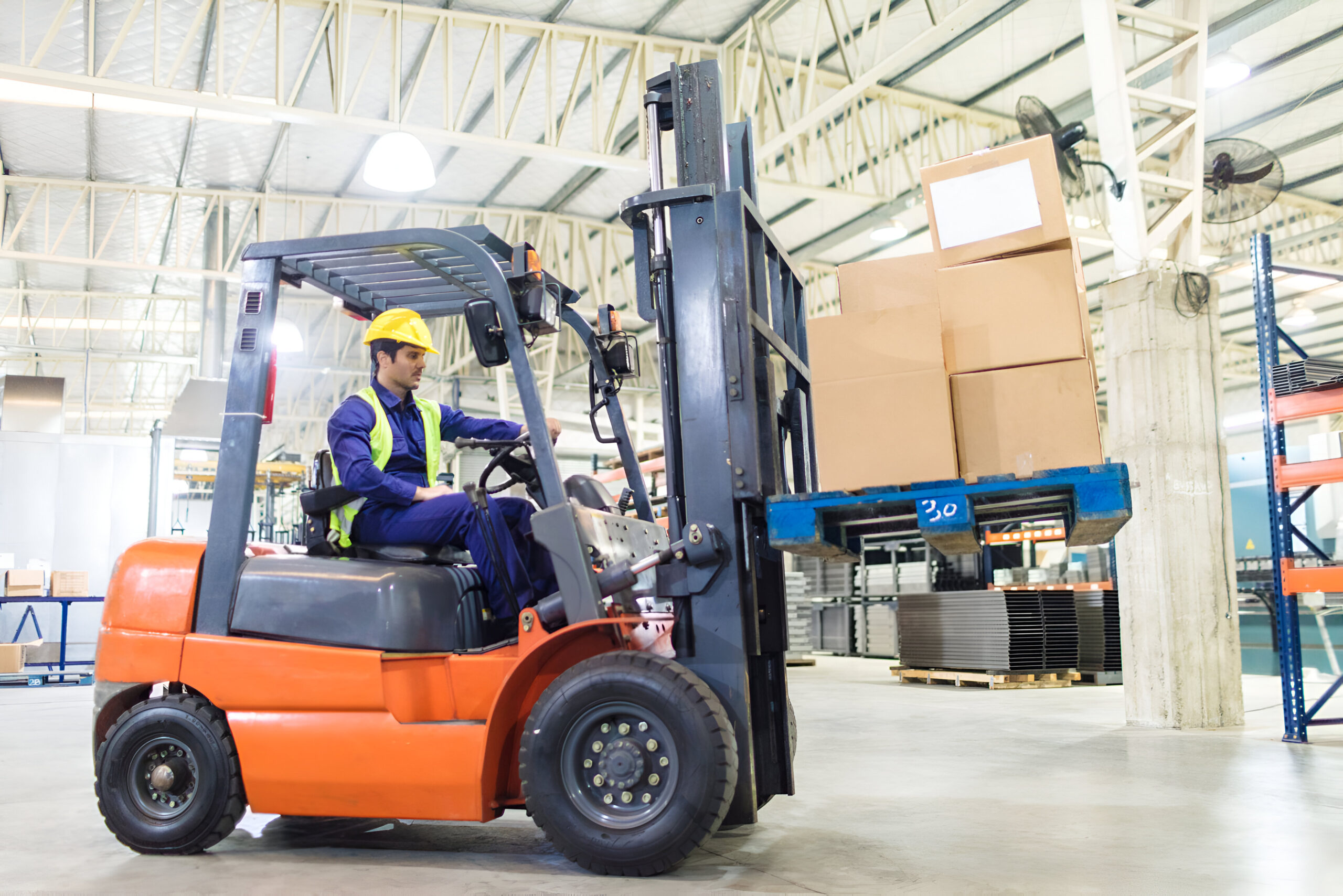 Worker driving a forklift in warehouse